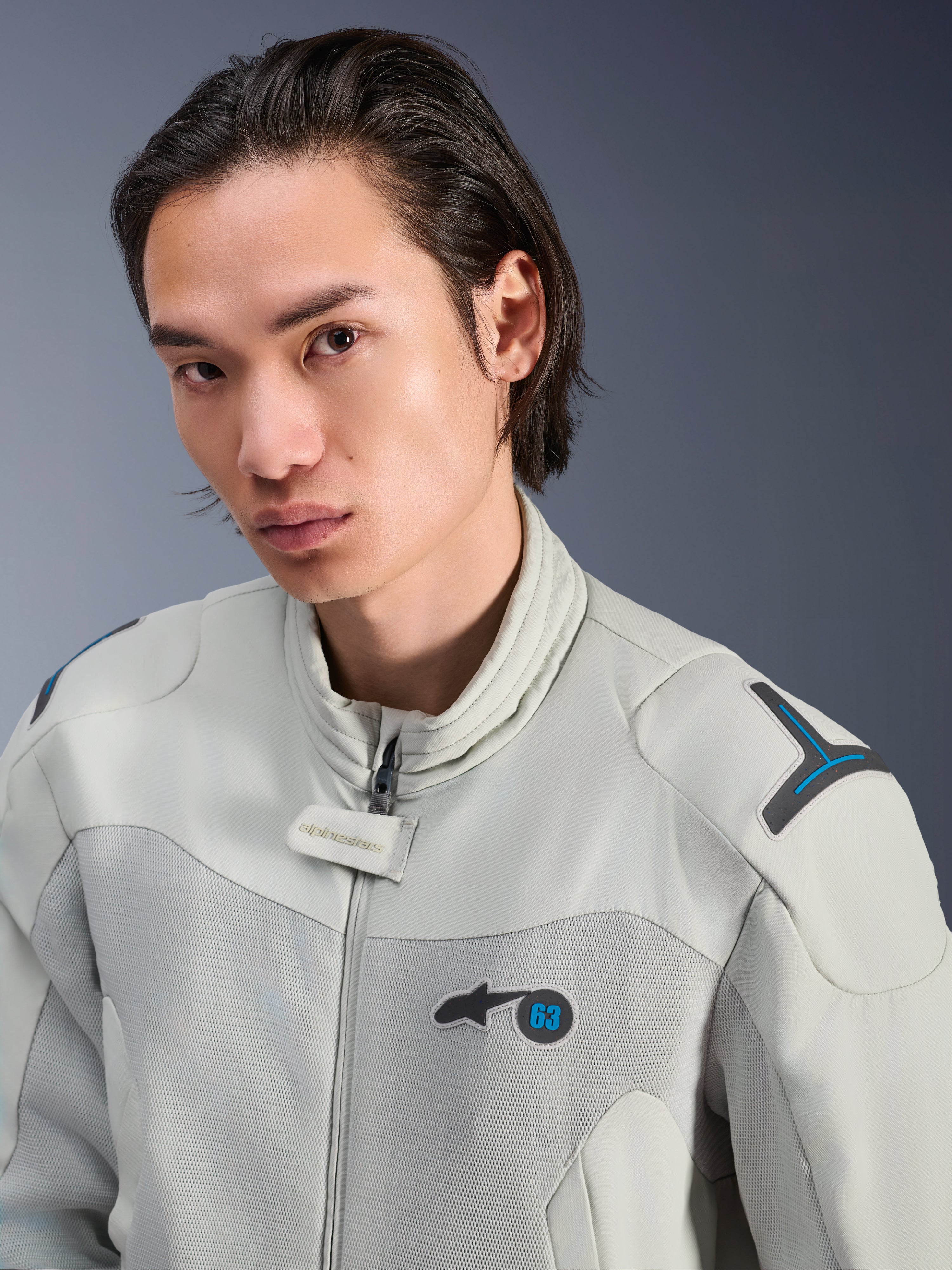 Alpinestars Circal-1 Air Jacket, Metal Gray met Methyl Blue accenten, mannelijk model draagt urban zomer motorjas, close-up van mesh ventilatiepanelen en minimalistische branding op de borst