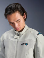 Mannelijk model draagt de Alpinestars Circal-1 Air Jacket in Metal Gray met Methyl Blue accenten, close-up weergave van de kraag, mesh borstpanelen en minimalistische logo-branding, duurzame stedelijke motoruitrusting.