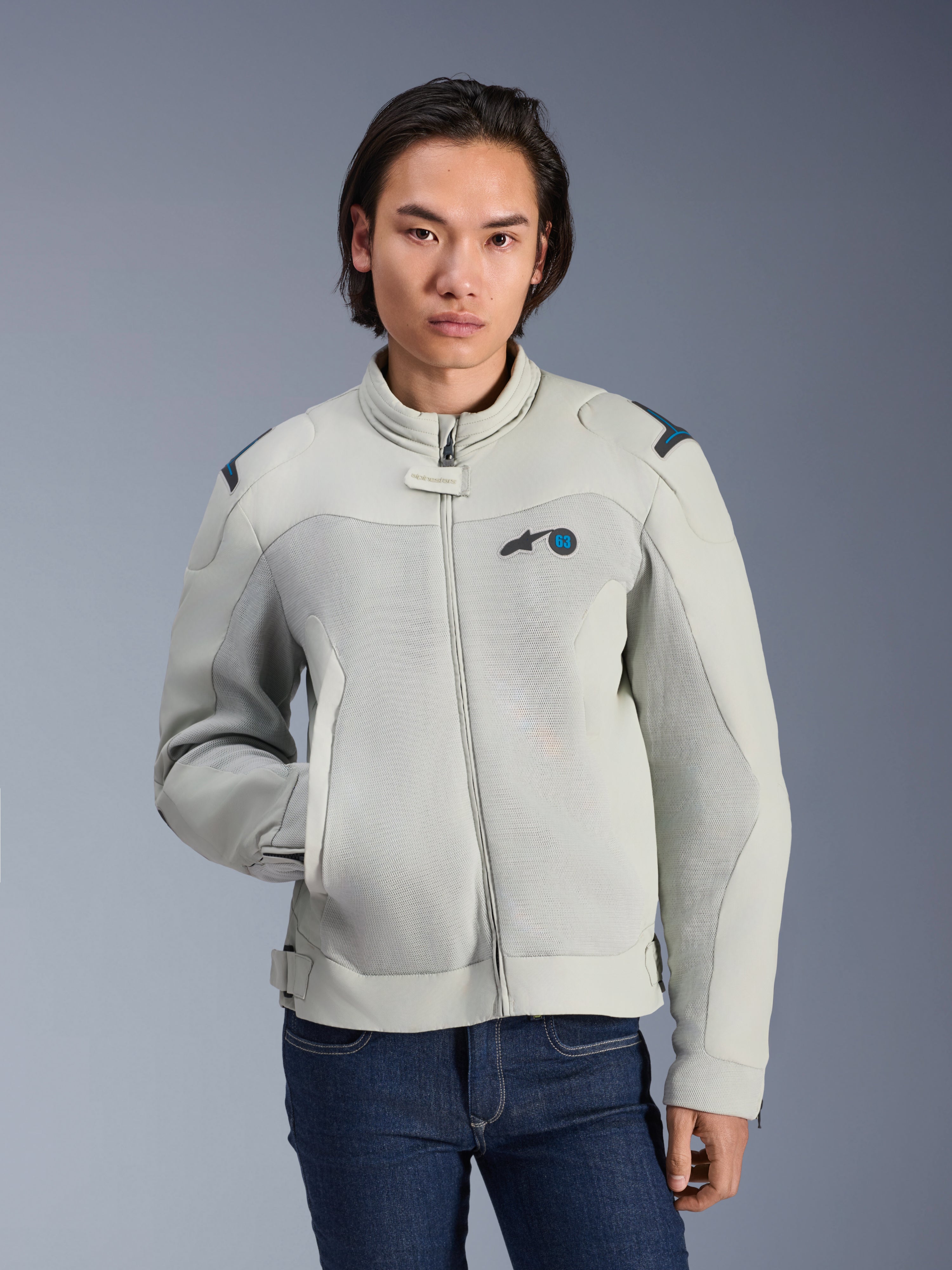Alpinestars Circal-1 Air Jacket, Metal Gray en Methyl Blue, urban motorjas met mesh ventilatiepanelen, ritssluiting aan de voorzijde en een gewatteerde kraag, gedragen door een model met een blauwe jeans, futuristisch duurzaam ontwerp voor ritten in de zomer