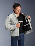 Alpinestars Circal-1 Air Jacket, metaalgrijs, opengehouden om de mesh voering aan de binnenkant en zakdetails te tonen, gedragen door een model met een zwart logo T-shirt en blauwe jeans, urban motorstijl