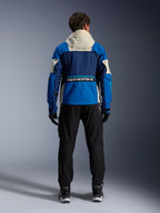 Alpinestars Mogress Air Jas in Blue Almond, achteraanzicht van een motorrijder die de motorjas draagt, voorzien van donkerblauwe en felblauwe panelen met een gebroken witte capuchon, opvallend Alpinestars-logo op de onderrug, urban contemporary kledingstijl.