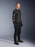 Alpinestars T-Dyno Air Jacket, zwarte textiel motorjas, voorzien van drie witte Alpinestars-logo's op de mouw, gedragen met bijpassende zwarte broek en handschoenen, urban motorkleding met ademende mesh-panelen
