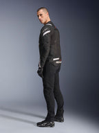Alpinestars T-Stunt Air Jacket, zwart en wit, modulaire motorjas met tech mesh-panelen, afgebeeld in zij-achteraanzicht op een model, gedragen met zwarte motorbroek en schoenen, witte accenten en branding op de schouders en rug.