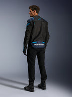Alpinestars T-Stunt Air Jacket, motorjas, zwart met donkerblauwe en Blithe Blue accenten, achteraanzicht met modulaire mesh-panelen en branding op de onderrug, gedragen door een model met zwarte motorbroek en laarzen.