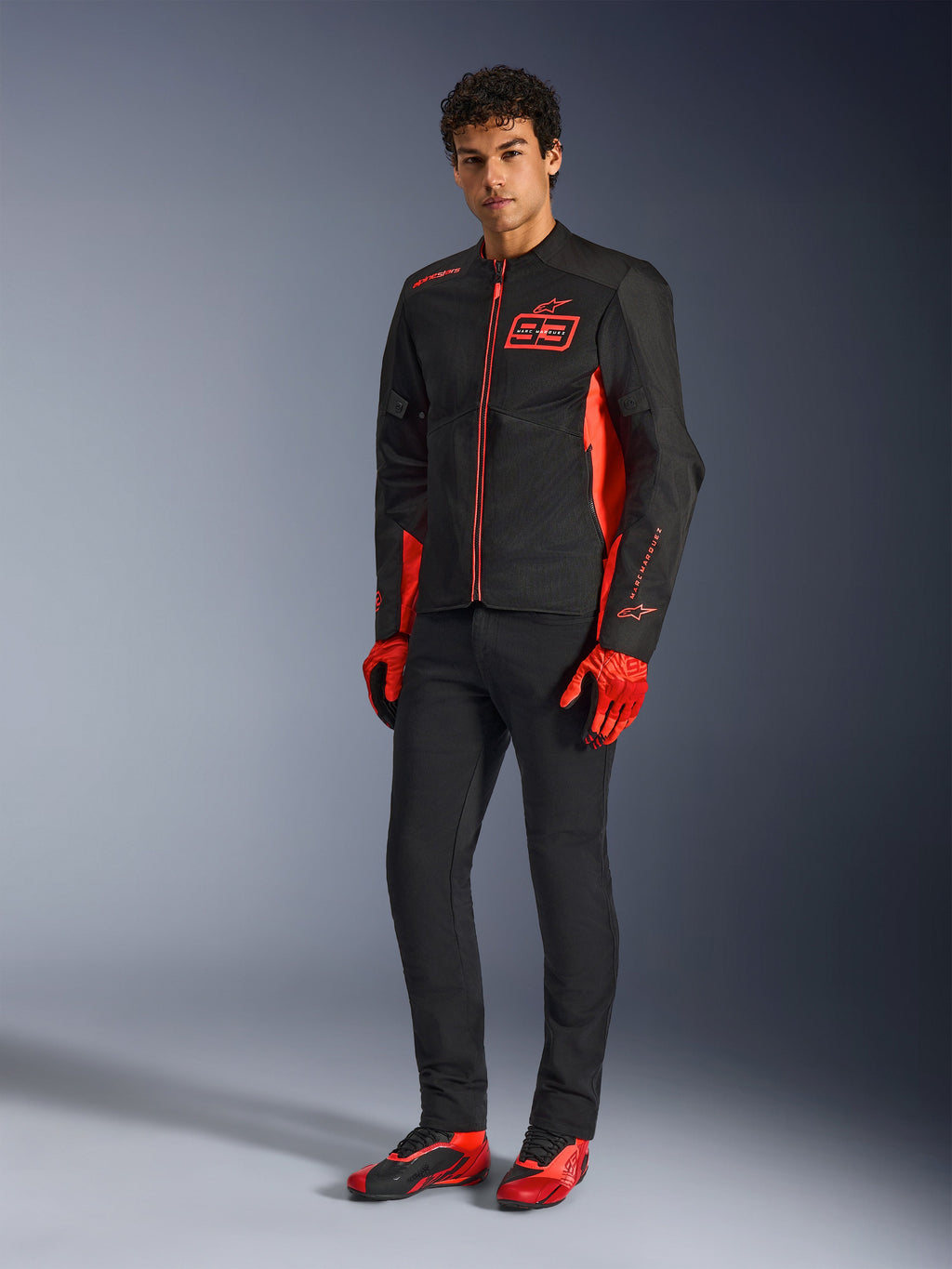 Alpinestars MM93 C-1 Air Jas, motorjas, Red Fluo Bright Red en zwart, gedragen met rode handschoenen, zwarte broek en rode motorschoenen, voorzien van MM93-branding en lichtgewicht mesh-constructie, urban contemporary motorkleding