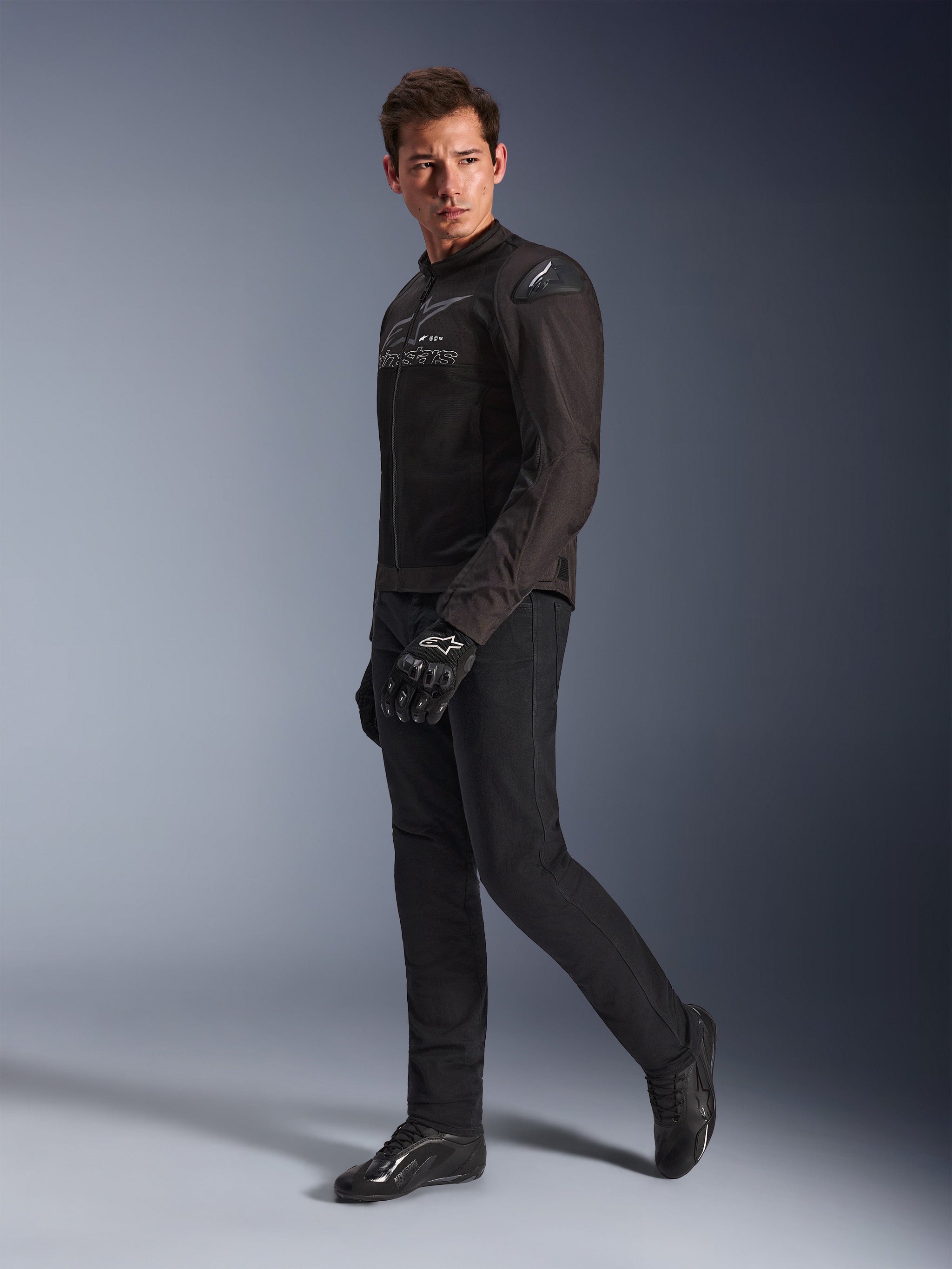 Alpinestars SMX Air Jas in Black Anthracite, gedragen door model met bijpassende zwarte motorbroek, handschoenen en schoenen, studio-opname van het volledige lichaam, sportieve motoruitrusting met tech mesh en schoudersliders