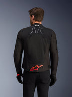 Alpinestars SMX Air Jacket, achteraanzicht, zwart met felrood Alpinestars-logo op de onderrug, voorzien van een technisch mesh-paneel voor een hoge luchtstroom en Tech-Air Ready-branding, gedragen door een mannelijke rijder met zwarte broek en handschoenen