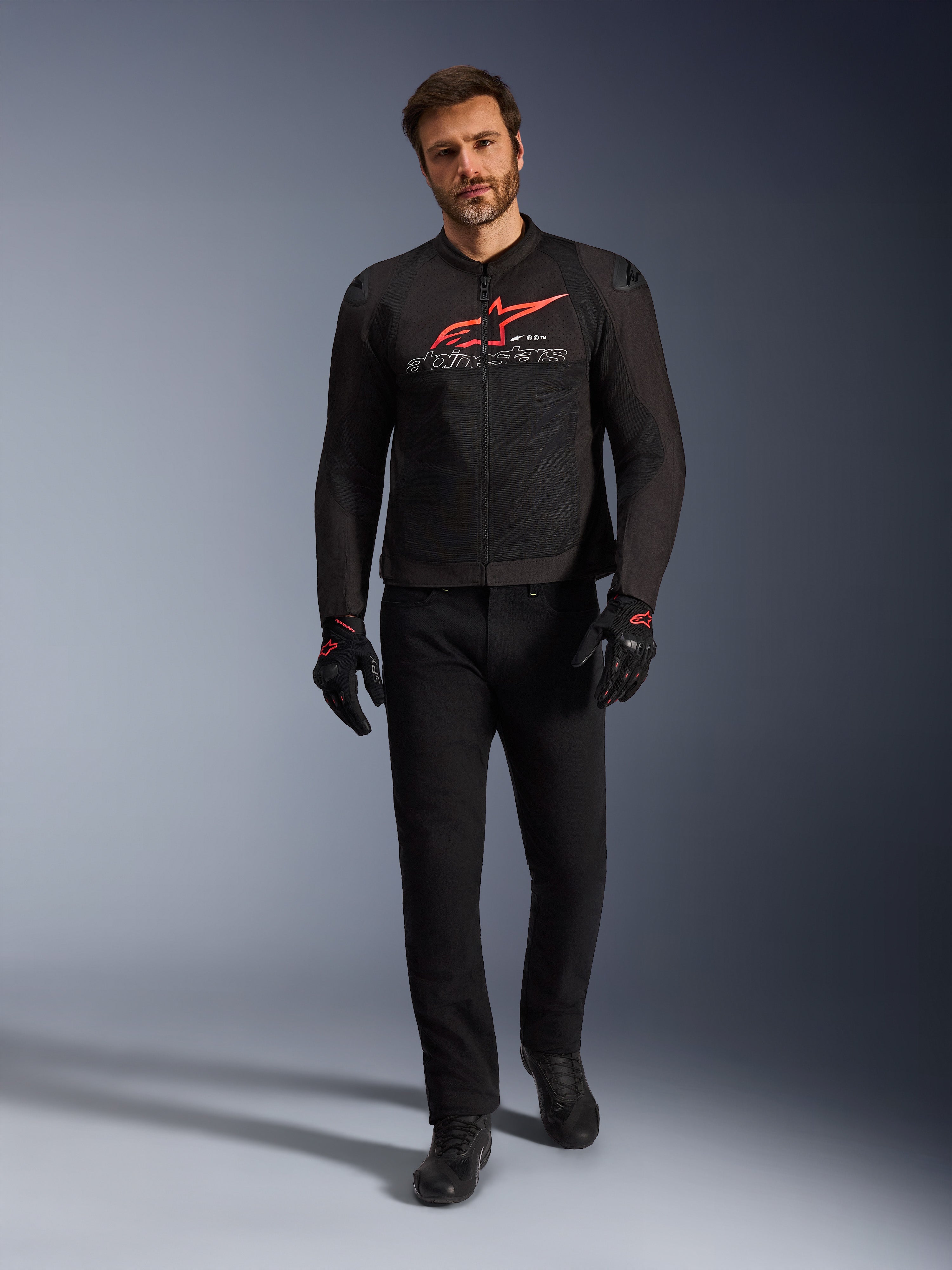 Alpinestars SMX Air Jacket, zwart, felrood en wit, sportieve motorjas gedragen met een zwarte motorbroek en handschoenen, voorzien van technische mesh-panelen en een opvallend rood Alpinestars-logo op de borst, performance street riding outfit