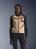 Alpinestars Stella Grace jas, motorjas voor dames, aluminium en zwart, op werkkleding geïnspireerd ontwerp met rozerode ritsaccenten, een spiraalvormige patch op de borst en zwarte mouwen met gele en rode graphics, gedragen door een model