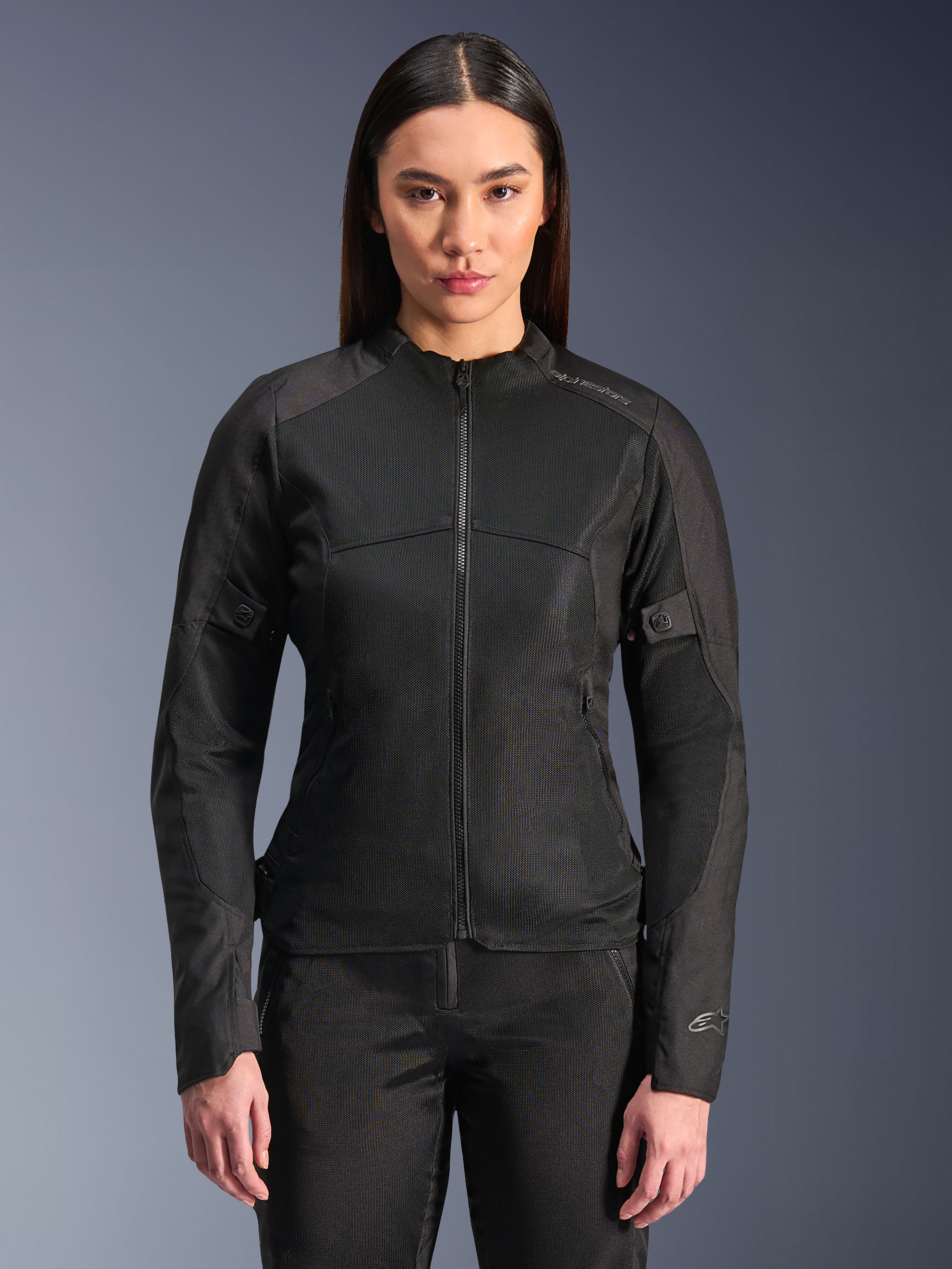 Alpinestars Stella C-1 Air Jacket, dames motorjas, zwart, model draagt een strakke jas met ritssluiting en tech mesh-panelen, slim fit ontwerp met subtiele reflecterende logo's op de schouder en mouwmanchet