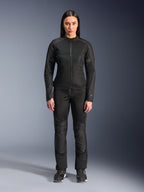 Vrouw in Alpinestars Stella C-1 Air Jas in het zwart, gecombineerd met bijpassende zwarte textiel motorbroek en motorschoenen, strak urban design met grote mesh-panelen voor optimale luchtstroom.