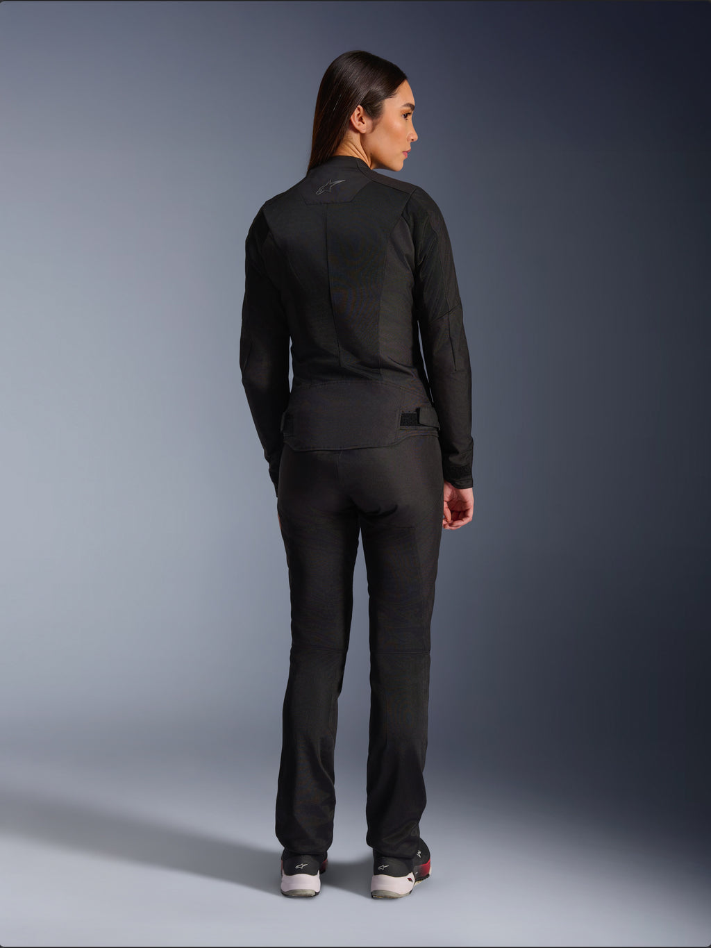 Alpinestars Stella C-1 Air Jacket, textiel motorjas voor dames, zwart, achteraanzicht met mesh-constructie en subtiel logo op de bovenrug, gedragen met bijpassende zwarte motorbroek, urban eigentijdse stijl