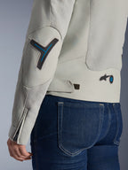 Alpinestars Stella Circal-1 Air damesjas in Metal Gray en Methyl Blue, close-up van de achterkant en mouw met mesh ventilatiepanelen, neonblauwe accenten op de elleboog en taille, verstelbare tab, gedragen met een donkerblauwe spijkerbroek.