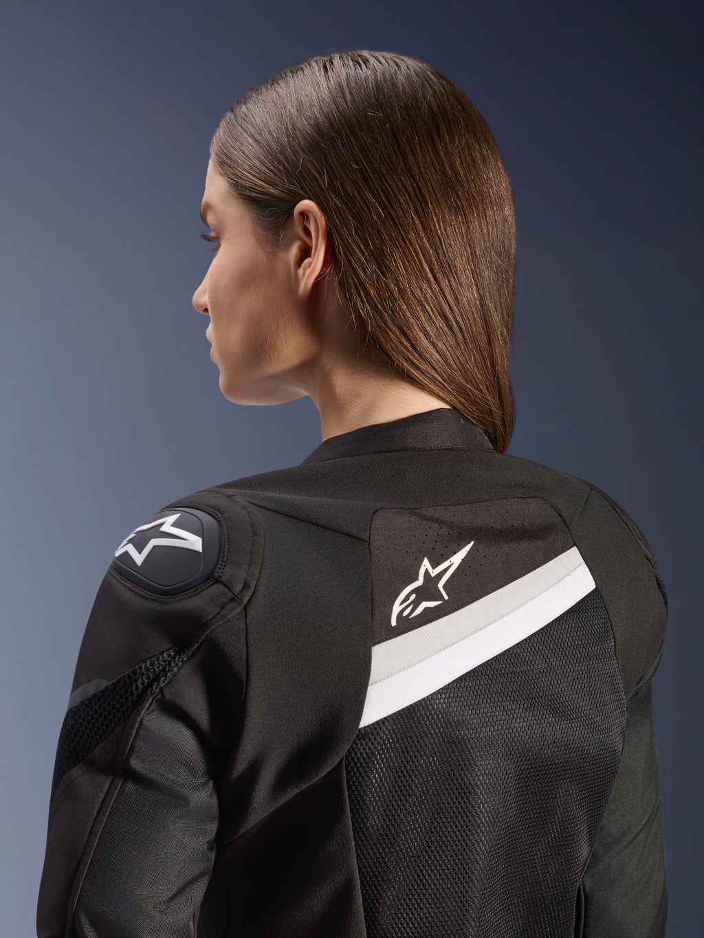 Alpinestars Stella T-GP Plus R V4 Airflow jas, sportieve dames motorjas, zwart en wit, voorzien van mesh achterpanelen en witte accenten, Alpinestars-logo op de schouder en rug, anatomische pasvorm voor sportief rijden