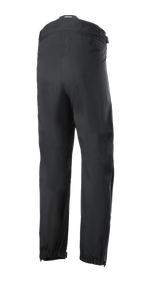 Alpinestars AMT Storm Gear Drystar® XF Pant, zwarte motoroverbroek, achteraanzicht met een verbindingsrits rondom de taille, elastische zomen en beenopeningen met rits voor rijden in natte weersomstandigheden.