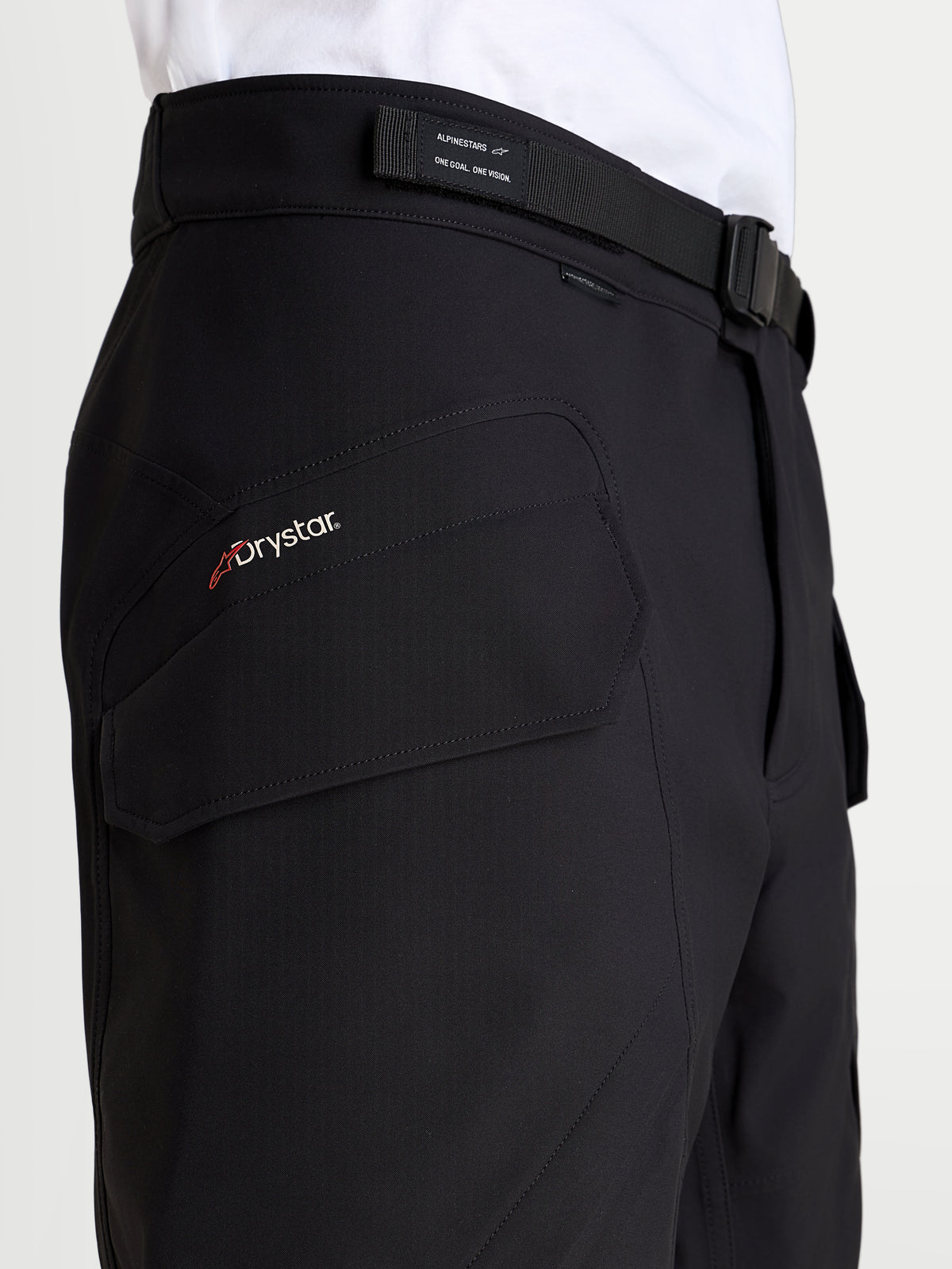 Alpinestars Juggernaut V2 Drystar broek, waterdichte urban motorbroek voor heren, zwart, detailopname van de zijdelingse cargozak met Drystar branding en verstelbare tailleriem