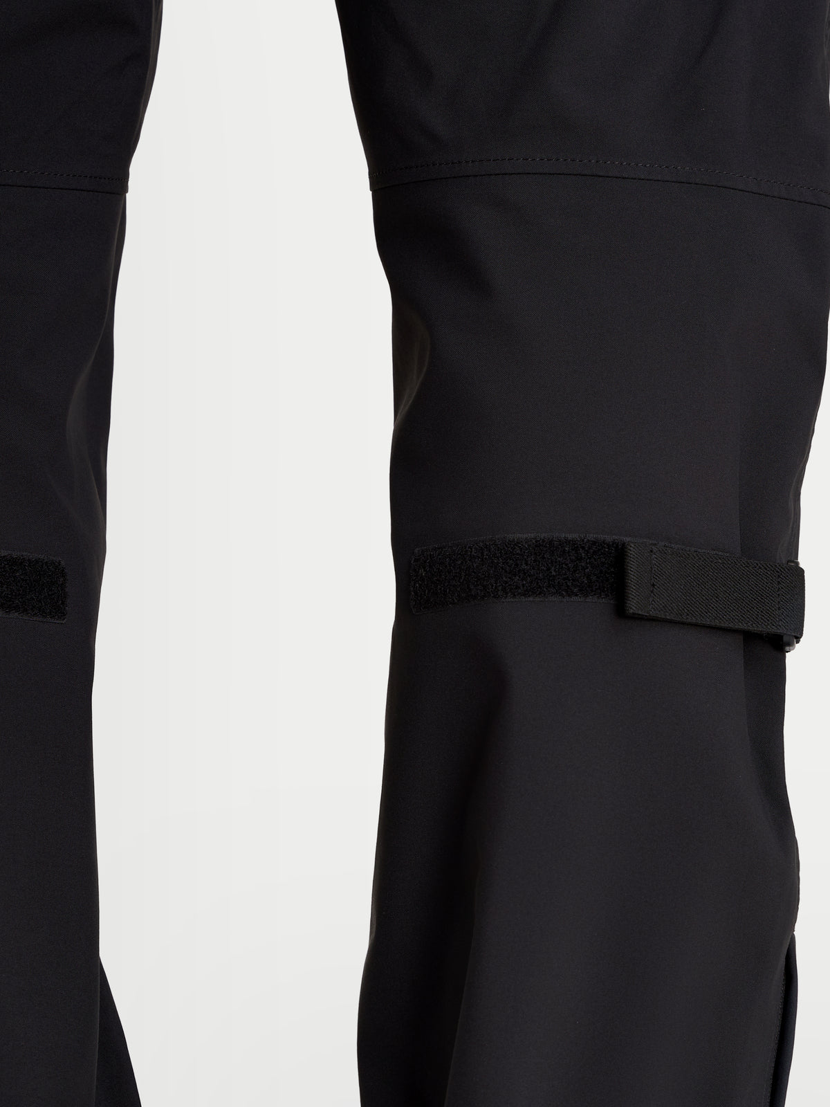 Alpinestars Juggernaut V2 Drystar broek, waterdichte urban motorbroek voor heren in zwart, detailopname van de onderbeenverstellingen en technische textielconstructie