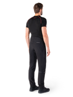Alpinestars Alden broek, zwarte urban motorbroek, achteraanzicht op een model, gedragen met zwarte basislaag met korte mouwen en zwarte motorschoenen, voorzien van gewatteerde details en reflecterende MO.ST.EQ. branding op de achterpas
