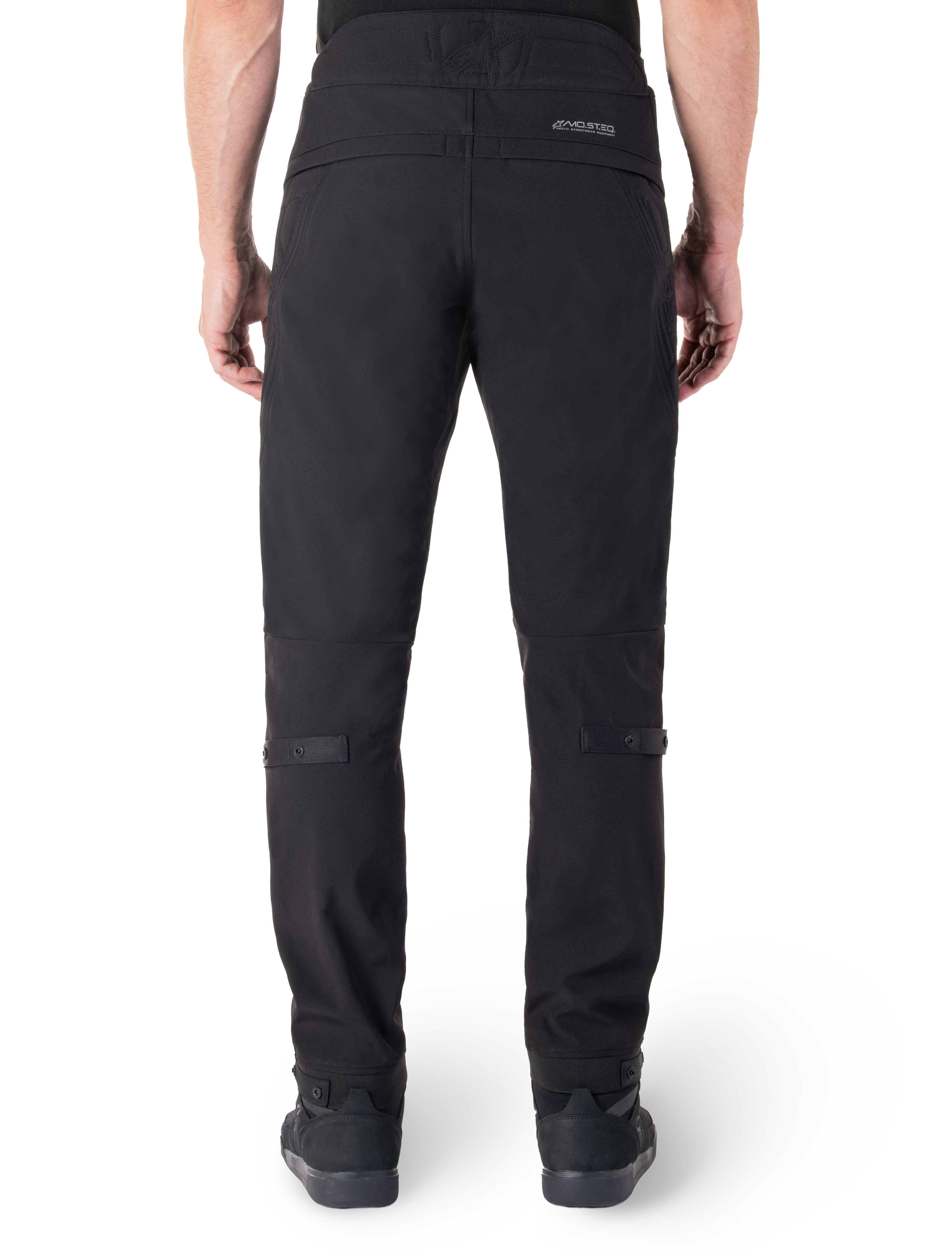 Alpinestars Alden broek, zwarte urban motorbroek, achteraanzicht, met reflecterend MO.ST.EQ.-woordmerk op de achterpas, slanke pasvorm onder de knie en volumeregelaars met drukknopen op de kuiten en manchetten, streetwear-geïnspireerd technisch textielontwerp.