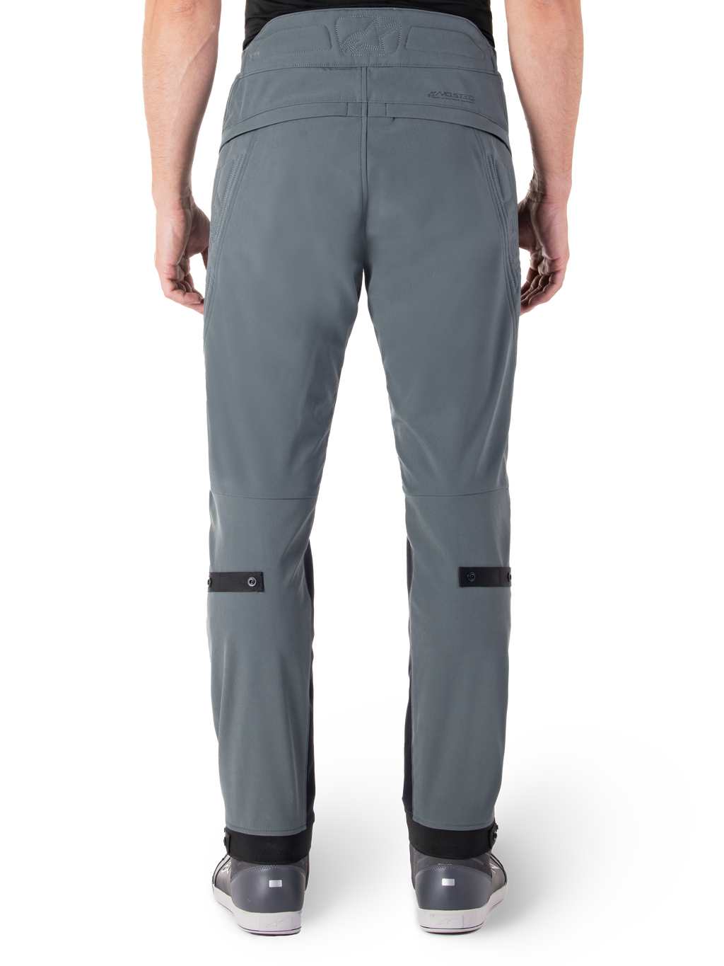 Alpinestars Alden broek, Urban Gray, achteraanzicht van een stedelijke motorbroek voor heren, slim fit onder de knie met zwarte verstelbanden op de kuiten, ontwerp met hoge taille voorzien van het MO.ST.EQ.-woordmerk op de achterpas, gedragen met grijze rijdschoenen
