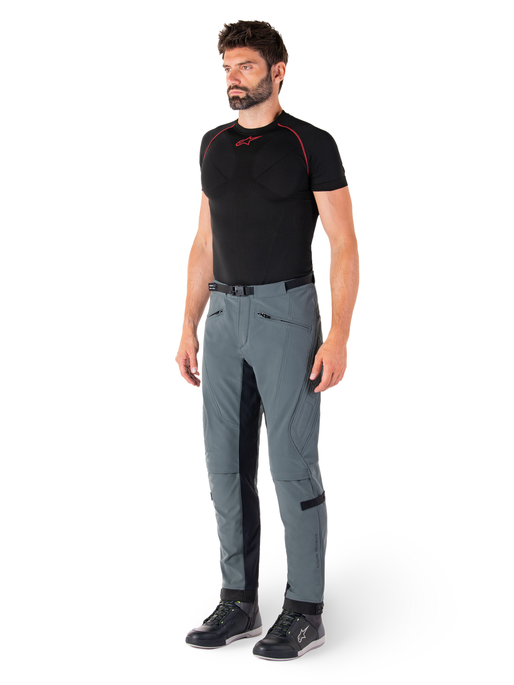 Alpinestars Alden broek, Urban Gray technische motorbroek, voorzien van gewatteerde zijpanelen en zwart stretchmateriaal aan de binnenkant van de benen, gestyled met een zwarte basislaag en motorschoenen, streetwear-geïnspireerde stedelijke motorkleding