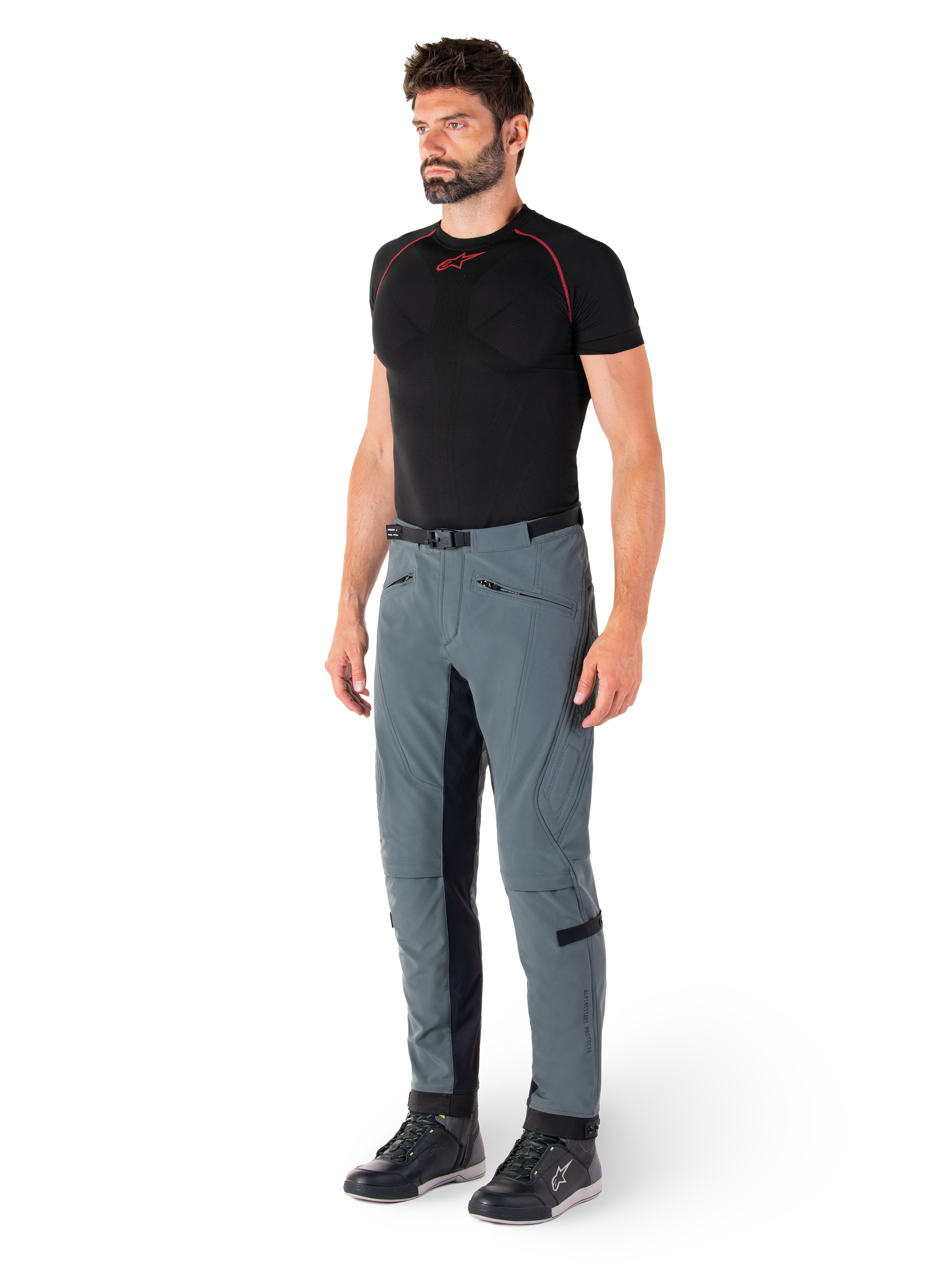 Alpinestars Alden broek, Urban Gray technische motorbroek, voorzien van gewatteerde zijpanelen en zwart stretchmateriaal aan de binnenkant van de benen, gestyled met een zwarte basislaag en motorschoenen, streetwear-geïnspireerde stedelijke motorkleding