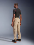 Alpinestars Flex-AST Cargo Broek - Kort, urban motorbroek in lichtbeige, driekwart achteraanzicht met cargozakken aan de zijkant en elastische zomen, gestyled met een zwarte top met korte mouwen en zwarte vrijetijdsschoenen