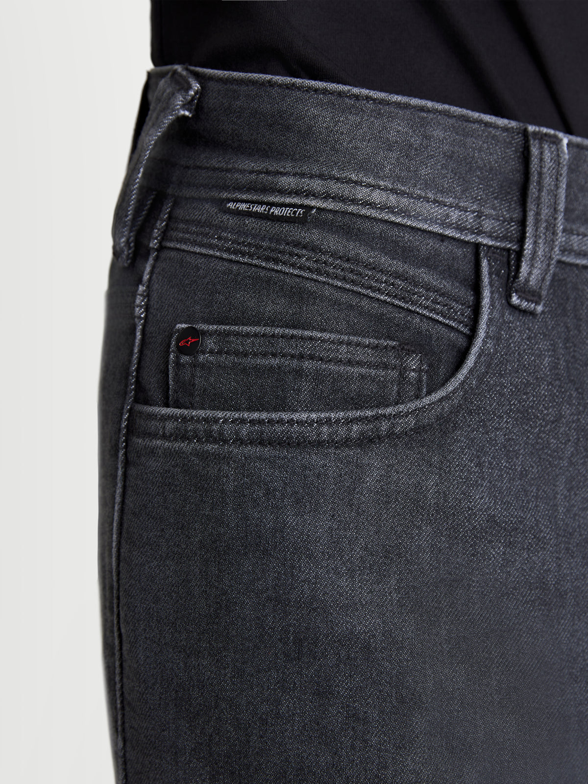 Alpinestars Flex Ast 7 Denim broek, urban motorjeans voor heren in vervaagd zwart, detailopname van de zakconstructie, klinknageldetail met logo en Alpinestars Protects-geweven label