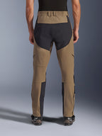 Alpinestars Flex-AST Explorer Pants, adventure motorbroek, Walnut Black, achteraanzicht gedragen door rijder, zwarte ripstop-verstevigingspanelen op het zitvlak en de binnenkant van de benen, elastische tailleband, lange ritsen aan het onderbeen en bijpassende adventure-laarzen
