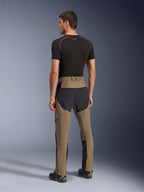 Alpinestars Flex-AST Explorer Broek, adventure motorbroek, Walnut Black, achteraanzicht op model met zwarte ripstop-panelen op het zitvlak en de benen, stretch textielconstructie en lange ritsen aan de onderbenen voor adventure touring