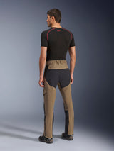 Alpinestars Flex-AST Explorer Broek, adventure motorbroek, Walnut Black, achteraanzicht op model met zwarte ripstop-panelen op het zitvlak en de benen, stretch textielconstructie en lange ritsen aan de onderbenen voor adventure touring