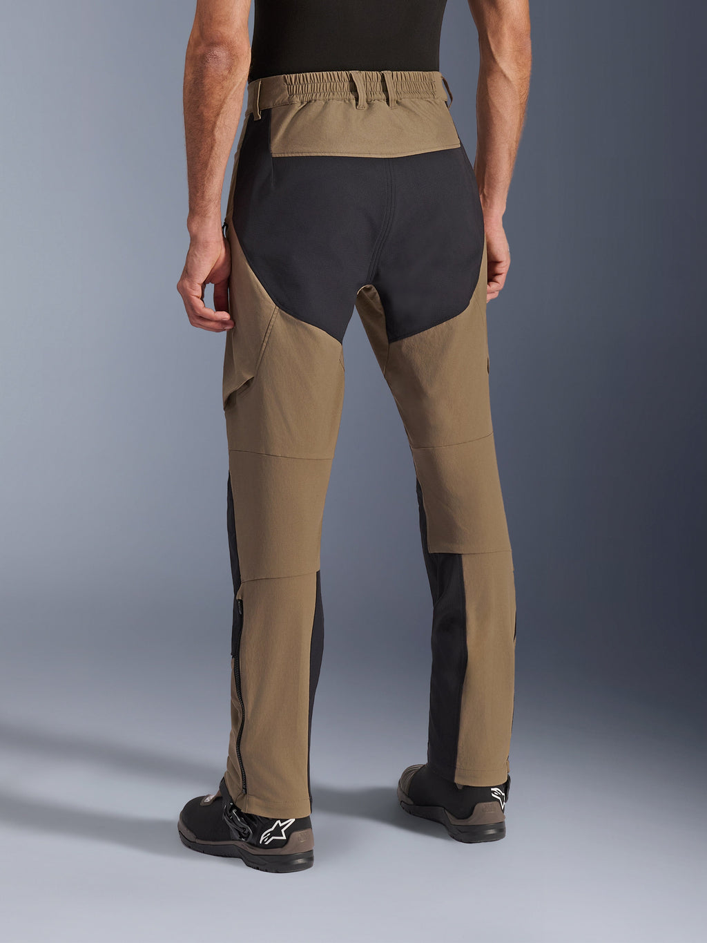 Alpinestars Flex-AST Explorer broek, Walnut Black adventure motorbroek, achteraanzicht met zwarte ripstop panelen op het zitvlak en de benen, elastische tailleband en duurzame stretch textielconstructie.