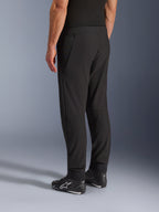 Alpinestars Aeroshell Airflow Pants, zwarte motorbroek, driekwart achteraanzicht, lichtgewicht stretch softshell constructie met geïntegreerde mesh-panelen, verstelbare enkelmanchetten, gedragen met zwarte Alpinestars motorschoenen