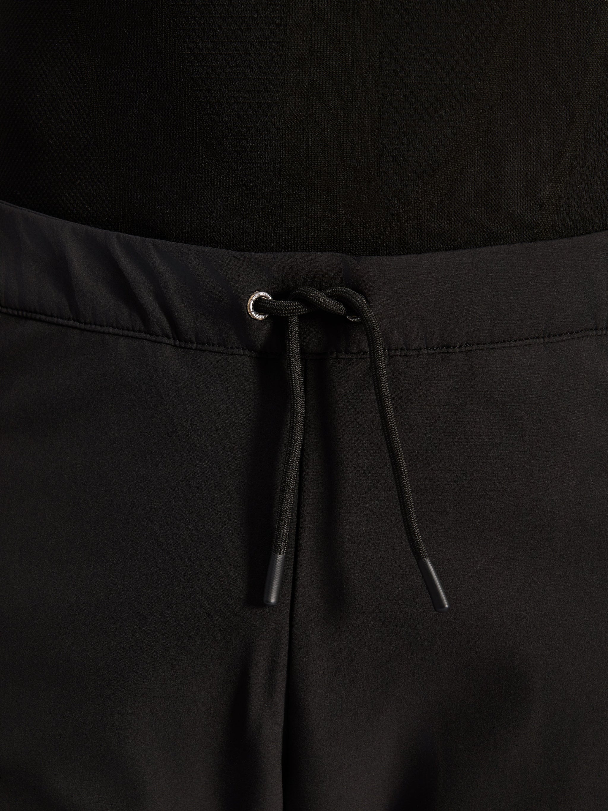 Alpinestars Aeroshell Airflow broek, zwart, close-up van de tailleband met verstelbaar intern elastisch trekkoord en zilverkleurig oogje, sport-touring motoruitrusting