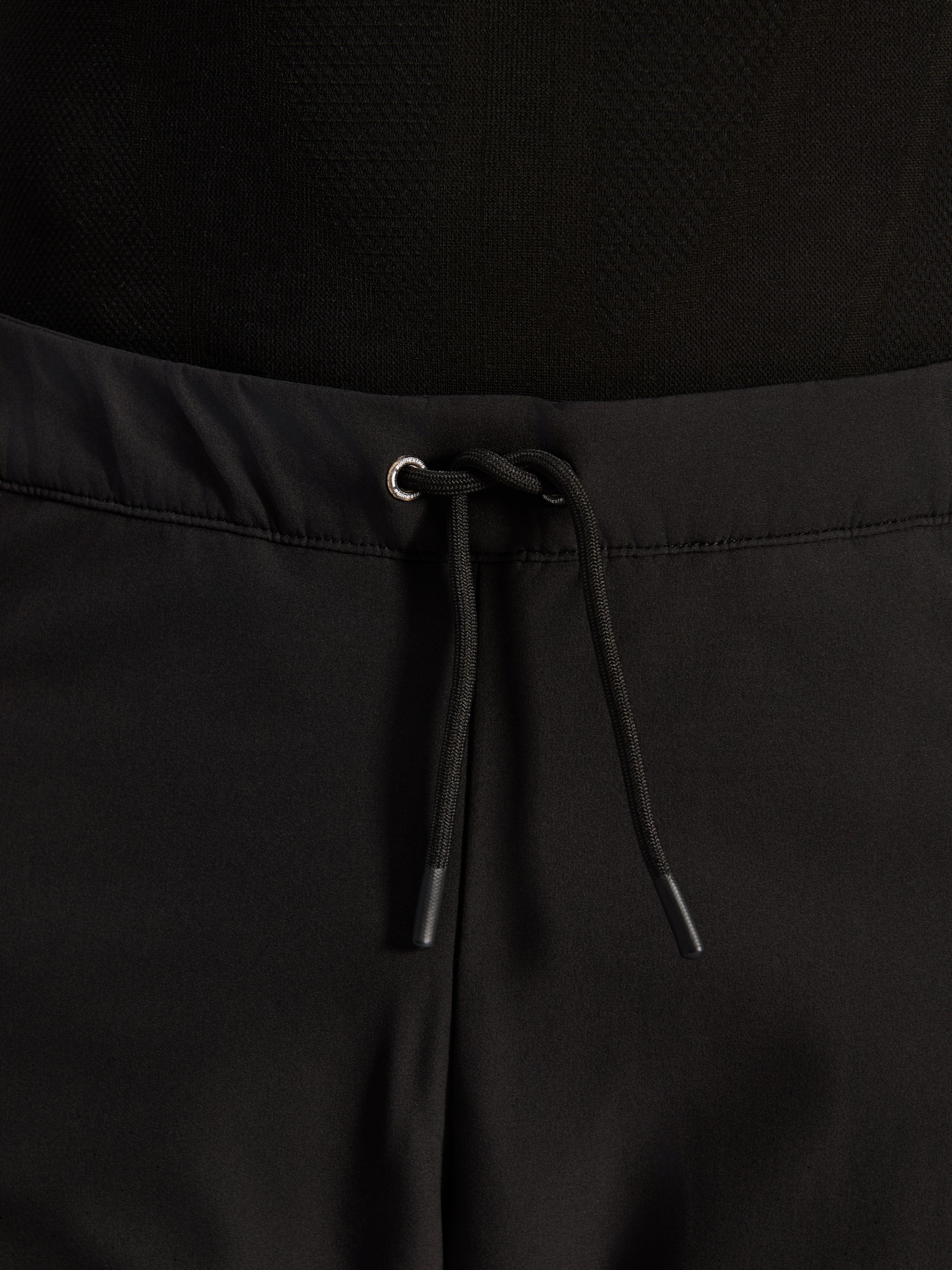 Alpinestars Aeroshell Airflow broek, zwart, close-up van de tailleband met verstelbaar intern elastisch trekkoord en zilverkleurig oogje, sport-touring motoruitrusting