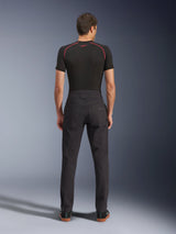 Alpinestars Flex-AST Canvas Pants, urban motorbroek, zwart, achteraanzicht met op werkkleding geïnspireerd ontwerp, achterzakken en verlengde rugstijging, gedragen met een zwarte basislaag en sneakers, ergonomische rijpasvorm
