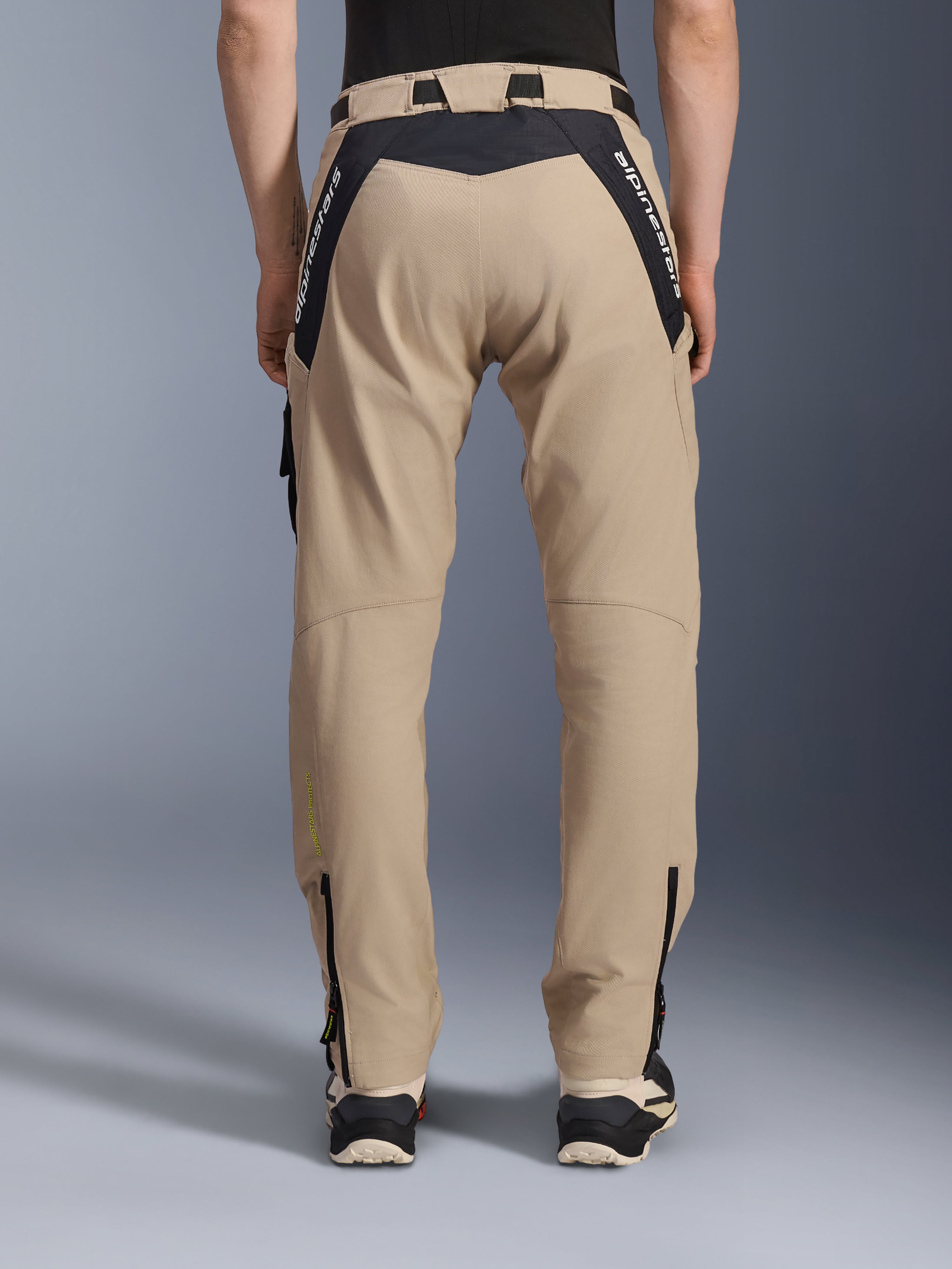 Alpinestars Acteon broek, urban motorbroek, sand, achteraanzicht met zwarte ripstop-panelen en witte merkaanduiding op de pas, taps toelopende pasvorm met ritsen onderaan de broekspijpen, eigentijdse motorkleding voor op de weg