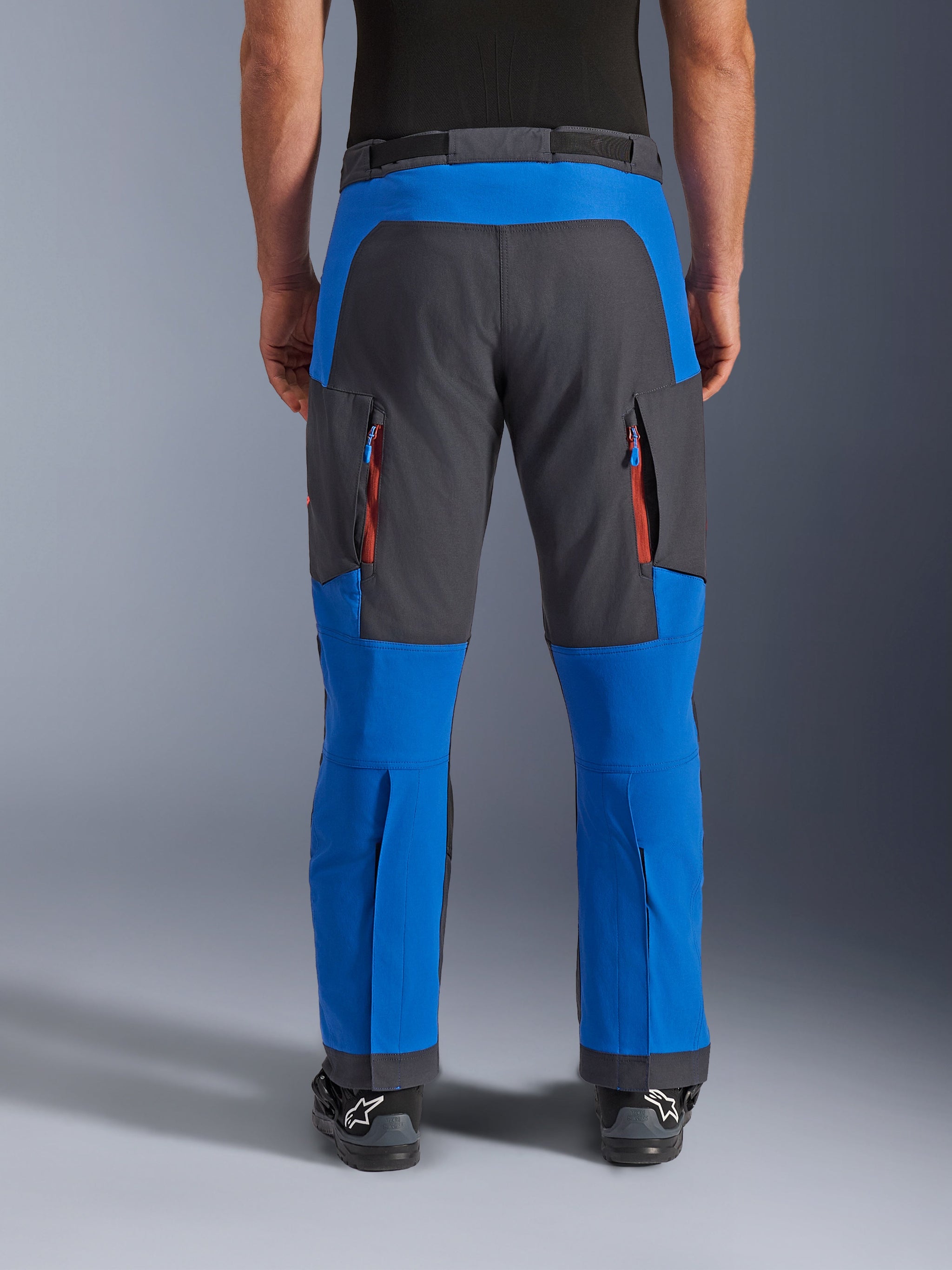 Alpinestars Maxdura Dual Pants, adventure motorbroek, koningsblauw en diepgrijs, achteraanzicht met verticale ventilatieopeningen met rits op de dijen en verstevigde zitvlakpanelen, over-de-laars ontwerp, technische uitrusting voor dual-sport rijden