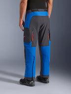 Alpinestars Maxdura Dual broek, Royal Blue en Deep Gray, achteraanzicht met ritszakken en ventilatiezones, over-de-laars ontwerp gedragen met zwarte Alpinestars laarzen, duurzame adventure en dual-sport motorkleding