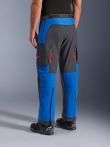 Alpinestars Maxdura Dual broek, Royal Blue en Deep Gray, achteraanzicht met ritszakken en ventilatiezones, over-de-laars ontwerp gedragen met zwarte Alpinestars laarzen, duurzame adventure en dual-sport motorkleding