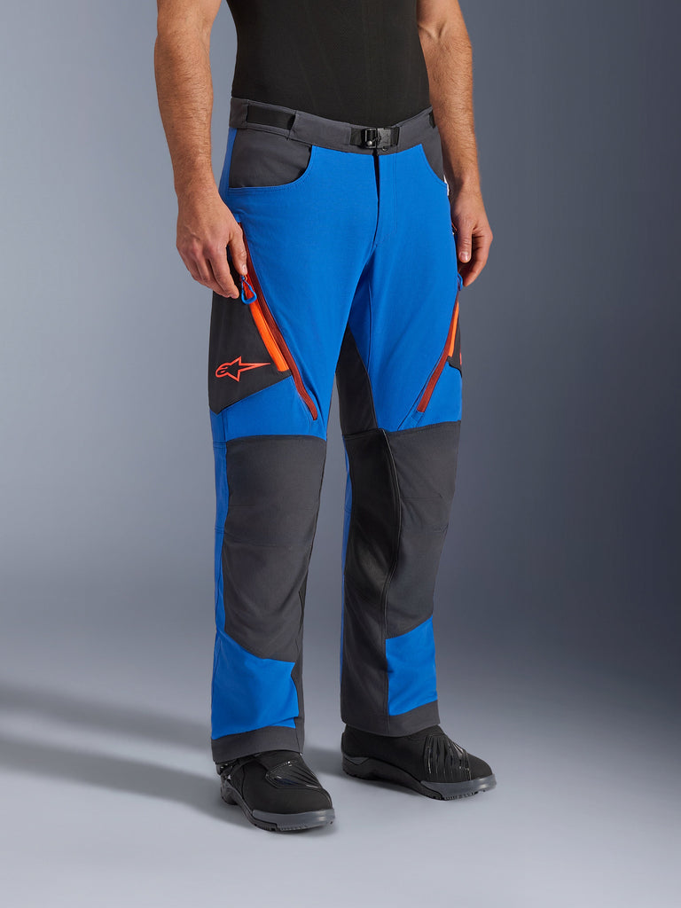Alpinestars Maxdura Dual Pants, adventure motorbroek, koningsblauw en diepgrijs met oranje accenten, ritsventilatie op de dijen, verstevigde kniepanelen, riem met magnetische gesp, technisch over-de-laars ontwerp voor dual-sport rijden