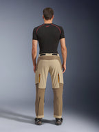 Alpinestars Maxdura Dual Pants in Walnut Aluminum, achteraanzicht met tweekleurig bruin en beige ontwerp, adventure motorbroek met cargozakken met ritssluiting en versterkt zitvlak, gedragen met een zwart compressieshirt en motorlaarzen