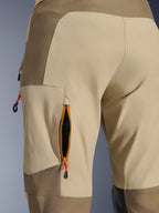 Alpinestars Maxdura Dual Pants in Walnut Aluminum, detailopname van ventilatieopening op de dij met ritssluiting, oranje bies en zwart mesh, tan en bruine heavy-duty stretch polyamide stof met rode treklussen