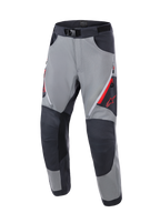 Alpinestars Maxdura Dual Pants, adventure motorbroek, donkergrijs en diepgrijs, met versterkte donkergrijze kniepanelen, rode ventilatieopeningen met rits op de dijen, rood Astars-logo op de dij en een verstelbare tailleband met magnetische gesp, ontworpen voor dual-sport ritten