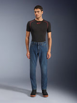 Alpinestars Flex-AST 5 Denim Pants, Motorcycle Denim Pants, Indigo Washed, worn with a black performance t-shirt and black sneakers, featuring a tapered fit and monolayer stretch denim construction for urban riding