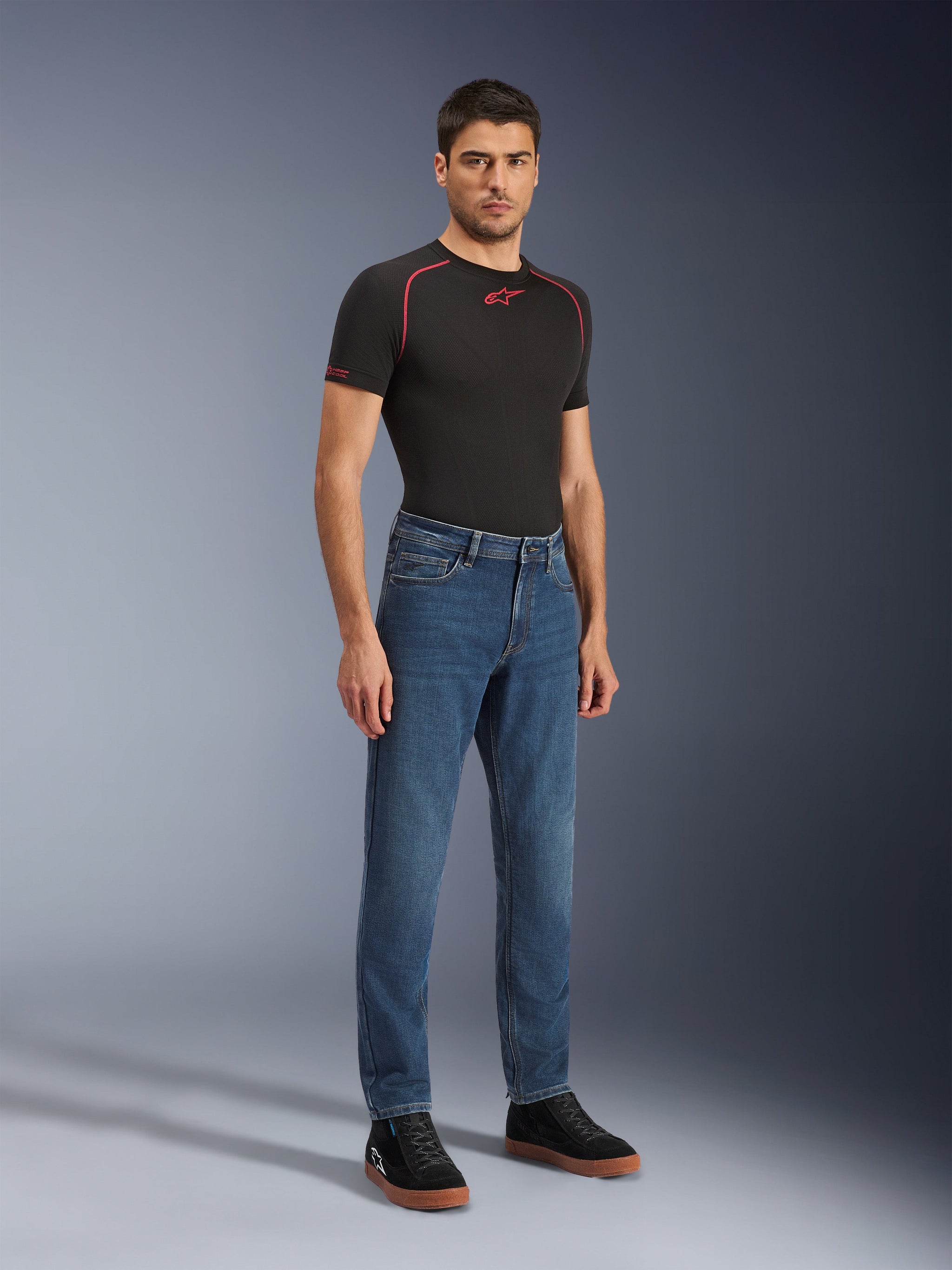 Alpinestars Flex-AST 5 Denim Pants - Short, Indigo Washed, urban motorcycle jeans with a tapered fit, worn by a male model with a black tight-fitting shirt and black sneakers, classic denim style for road-to-street transitions