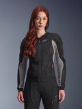 Alpinestars Stella Troop-Air dames motorjas, zwart, asgrijs en fluoriserend roze, gedragen door een model met bijpassende motorbroek, voorzien van geventileerde 2D tech mesh-constructie en roze logodetails, ontworpen voor stedelijke zomerritten