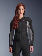 Alpinestars Stella Troop-Air dames motorjas, zwart, asgrijs en fluoriserend roze, gedragen door een model met bijpassende motorbroek, voorzien van geventileerde 2D tech mesh-constructie en roze logodetails, ontworpen voor stedelijke zomerritten