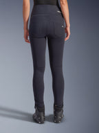 Alpinestars Stella Flex-AST Leggings, urban motorbroek, zwart, achteraanzicht met skinny pasvorm en hoge taille, twee functionele achterzakken met subtiele branding, stretch textielmateriaal, gedragen met zwarte motorschoenen