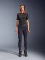 Alpinestars Stella Flex-AST Leggings, stedelijke motorleggings voor dames in het zwart, skinny model met hoge taille, gedragen met een zwart technisch shirt met korte mouwen en zwarte motorlaarzen, voorzien van harmonicavormige kniepanelen en een eigentijdse minimalistische look